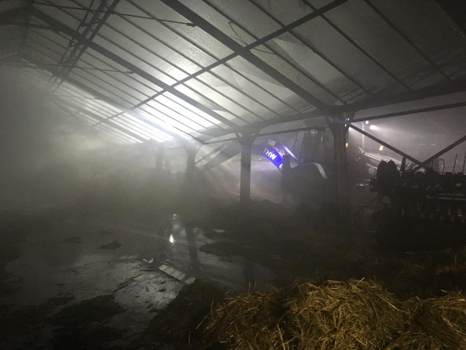 THW-Einsatzkräfte suchen nach Glutnestern in der verrauchten Halle des...