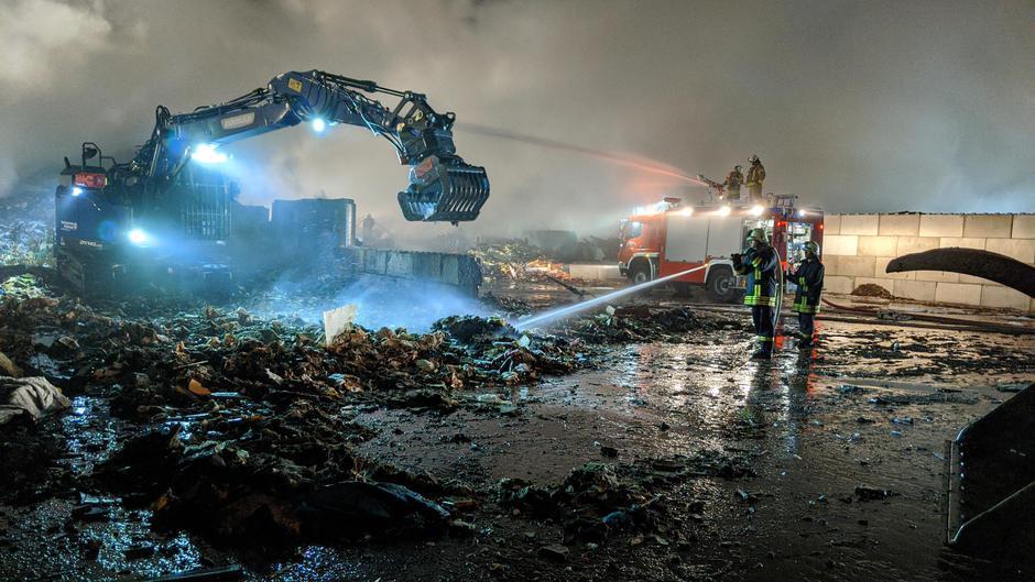 THW-Kräfte verteilten mit Hilfe des Baggers das Brandgut.