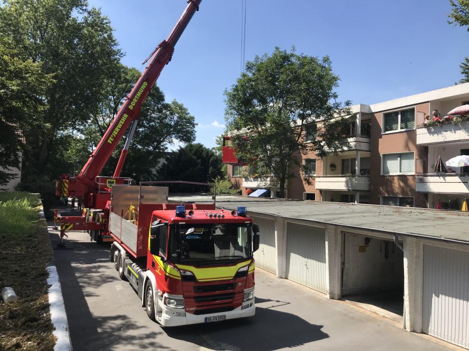 Der Kranwagen und ein Zubehörfahrzeug auf einem Garagenhof an der Einsatzstelle