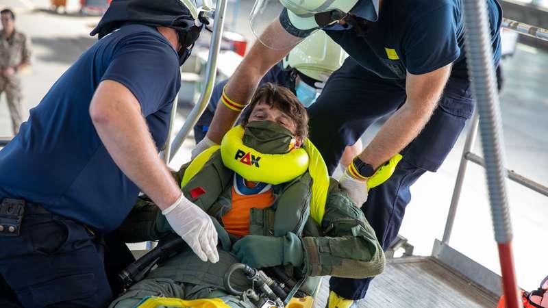 Nachdem der Pilot aus dem Cockpit befreit wurde, wird er auf einer...