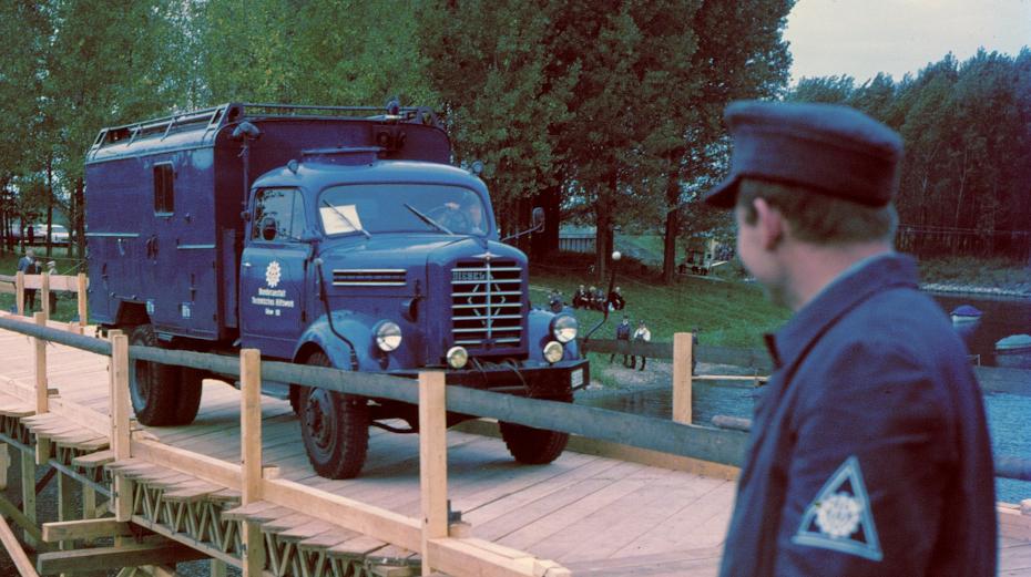 Borgward GKW auf einer THW gebauten Behelfsbrücke und THW-Helfer im blauen...