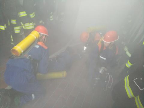 Jugendfeuerwehr bei einer Einsatzübung in einem verrauchten Gerätehaus zur...